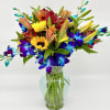 This arrangement highlights a combination of stunning blue orchids with the natural