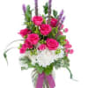 Purple liatris, roses and lovely hydrangia are arranged in a vase. 