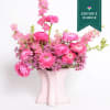 An arrangement of seasonal pink flowers in a handmade ceramic matte pink