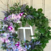 A beautiful round shape / wreath, accented with lavender roses, orchids, 