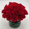 a beautifully designed round bouquet of deep red roses in crystal clear