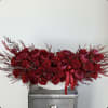 A luxurious vase arrangement featuring vibrant red roses and rich burgundy peonies.