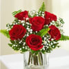 Timeless bouquet with red roses, baby breath and greens.