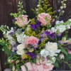 A white ceramic cylinder vase is filled with lovely pastel blooms of
