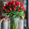 60 Red Roses arranged with greens in a vase