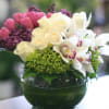 Orchids, roses, tulips etc. in a glass bubble bowl  