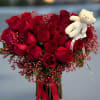 A stunning bouquet of radiant red roses arranged elegantly accented with baby&rsquo;s