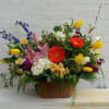 A Lush and Vibrant Mix of Flowers in a lovely reusable basket.

Please