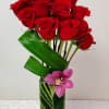 Luxurious Dozen Red Roses designed in a tall glass vase lined with