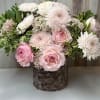 Mixed pink color flower arrangement in round wooden box.  