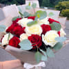 Two Dozens of white and red roses wrapped in waterproof wrapping paper.