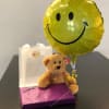 Classic teddy bear with a mylar balloon attached and a large box