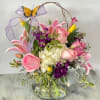 Arrangement of fresh cut flowers designed in a clear glass cylinder vase.