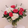 Arrangement in a vase with white hydrangea and pink roses filled with