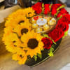 Sunflowers and red roses arranged beautifully in a heart shaped box with