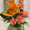 This vibrant arrangement radiates warmth and charm, featuring bold orange lilies
as the
