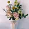 A white ceramic bud vase filled with seasonal flowers. 