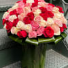 A crystal vase overflowing with 100 beautiful lush pink, ivory and red