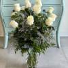 One dozen white roses accented with premium greens make a show stopping