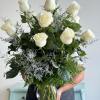 One dozen white roses accented with premium greens make a show stopping