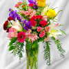 Beautiful arrangement with assorted flowers and greenery one side 