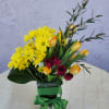 An elegant arrangement featuring daisy mums, tulips, and spray roses with a
