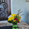 An elegant arrangement featuring daisy mums, tulips, and spray roses with a