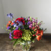 This arrangement is packed with vibrant colorful blooms to bring joy to