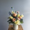Warm buttery sunset tones of roses, stock, tulips and delphinium in glass