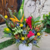 This vibrant tropical arrangement features an exotic mix of bold colors and