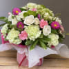 Sweetly sophisticated, this arrangement of green miniature hydrangea and light pink spray
