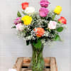 1 Dozen Assorted Mixed Roses in vase with greens and filler. 