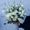 An elegant mix of white flowers in a tall white vase&mdash;a classic