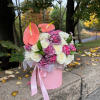 Delicate flower box with pink anthuriums, surrounded by white roses and purple