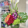 Fiesta Flower Arrangement: Beautiful flower arrangement in a fish bowl vase accented