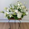 A large table flower centerpiece with premium white blooms and orchids and