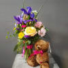 A bright arrangement paired with a cute soft teddy bear! Let your