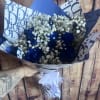 8 Blue Roses paired with babies breath wrapped in paper and tied