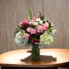 An arrangement of roses and hydrangeas in pink and white color for
