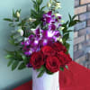 This charming arrangement combines the classic beauty of red roses with the