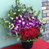 This charming arrangement combines the classic beauty of red roses with the