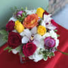 Joyful arrangement of Roses, Orchids, Hydrangeas, and Greens designed in a vase