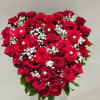 The arrangement features a heart-shaped bouquet of red roses, complemented by baby&#039;s