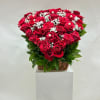 The arrangement features a heart-shaped bouquet of red roses, complemented by baby&#039;s