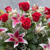 One dozen long stemmed red roses arranged with premium greens in our