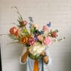 This arrangement is uniquely crafted with bright and fresh florals. Arrangement and
