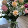 One dozen assorted color roses beautifully arranged in a glass vase