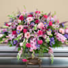 A beautiful half casket spray of pink and lavender mixed flowers.