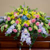 A beautiful half casket spray of pastel, spring mixed flowers.