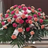 This classic half-couch casket spray with its dark and light pink carnations